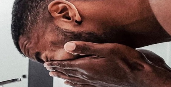 Man washing his face as part of a daily grooming routine